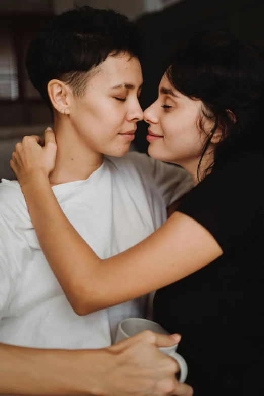 a couple of people that are hugging each other, by Julia Pishtar, lesbian embrace, low quality photo, genderless, brunettes