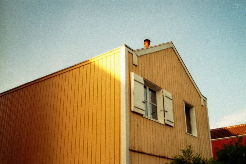 a house with shutters open on a sunny day, an album cover, inspired by Wes Anderson, unsplash, photorealism, backlit golden hour, low quality grainy, 1960s color photograph, sunset photo