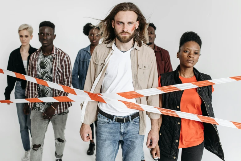 a group of people standing next to each other, by Matija Jama, pexels contest winner, antipodeans, police tape, a photo of a disheveled man, diverse outfits, plain background