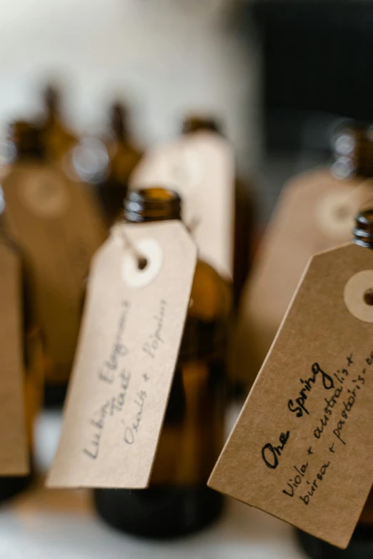 a group of brown bottles sitting on top of a table, a picture, unsplash, labels, carefully crafted, hanging, upclose