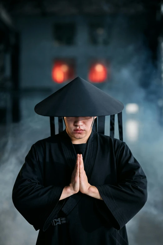 a man in a black robe and a black hat, an album cover, inspired by Ma Quan, unsplash, ninja warrior, praying, chinese costume, 2019 trending photo