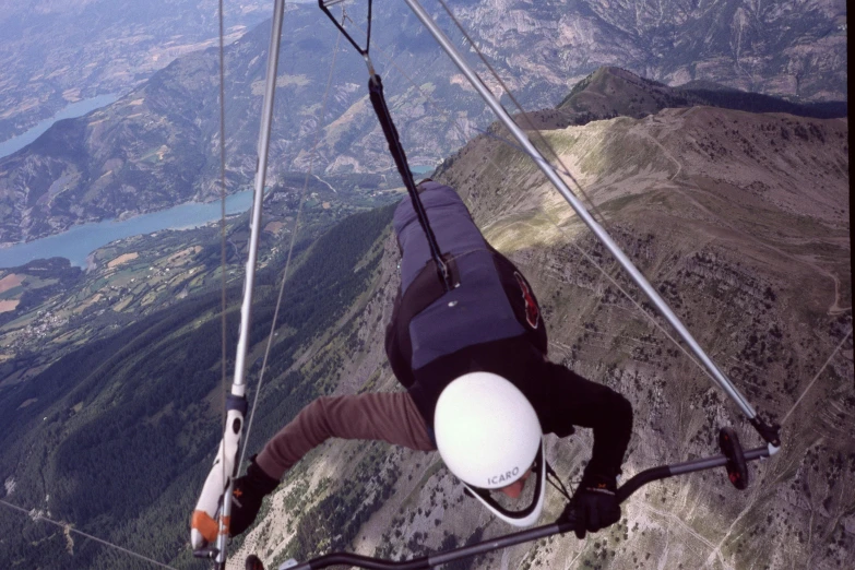 a man flying through the air on top of a mountain, helmet view, hanging cables, guillaume tholly, gliding