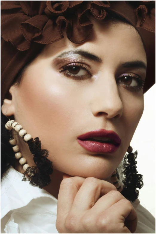 a close up of a person wearing a hat, inspired by Alfred Jensen, beautiful arab woman, dark lipstick, deep colour\'s, pearl earring