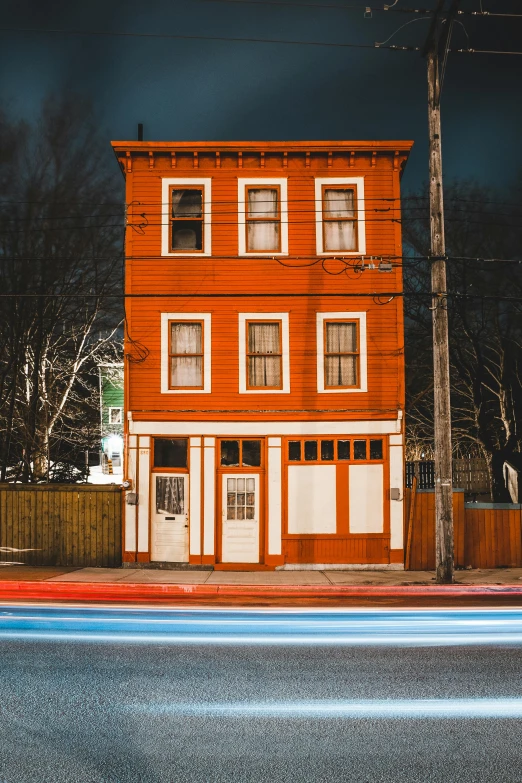 a red building sitting on the side of a road, a colorized photo, by Andrew Stevovich, pexels contest winner, neon glowing wood, victorian house, brown, neon greek