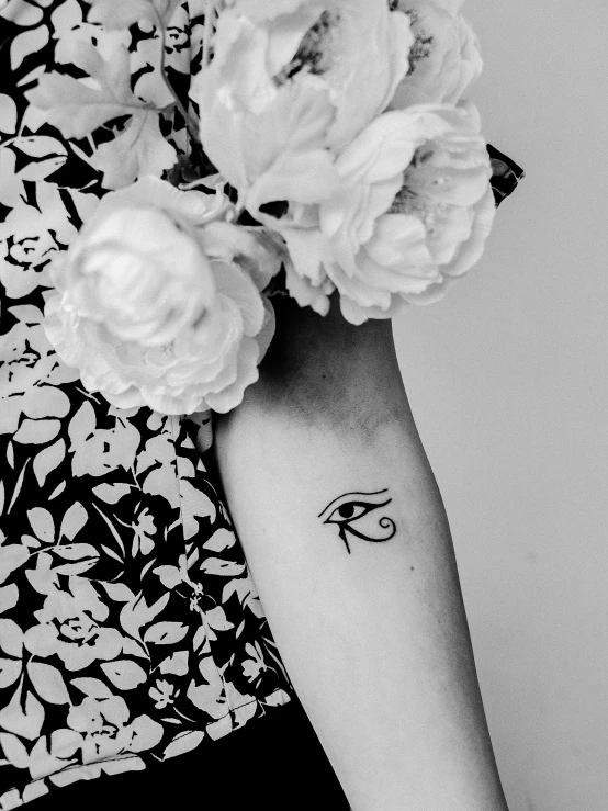 a black and white photo of a woman holding flowers, a tattoo, by Arabella Rankin, trending on unsplash, hurufiyya, eye of horus, singularity sculpted �ー etsy, smol, egyptian style