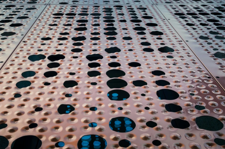 a close up of a metal structure with holes, inspired by Lucio Fontana, unsplash, interactive art, polka dot tables, melting in coral pattern, sidewalk, digitally enhanced