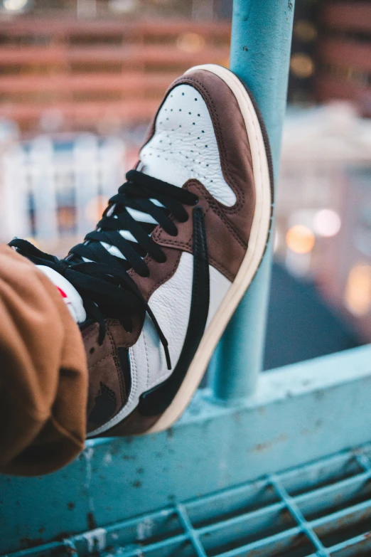 a close up of a person's shoes on a railing, trending on pexels, sots art, air jordan 1 high, sitting on a mocha-colored table, split dye, uniform off - white sky