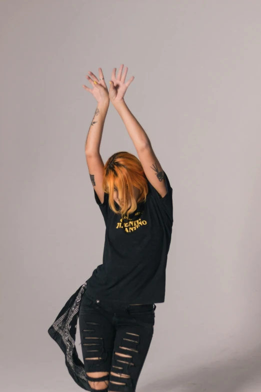 a woman that is standing up with her hands in the air, a tattoo, inspired by Yang J, antipodeans, wearing a dark shirt and jeans, official store photo, promotional image, long orange hair floating on air