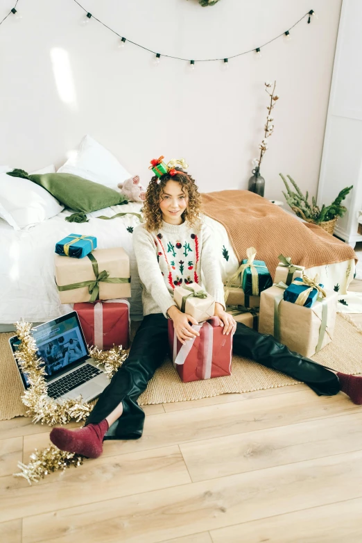 a woman sitting on the floor surrounded by presents, by Julia Pishtar, happening, curly haired, in front of a computer, promo image, sydney sweeney