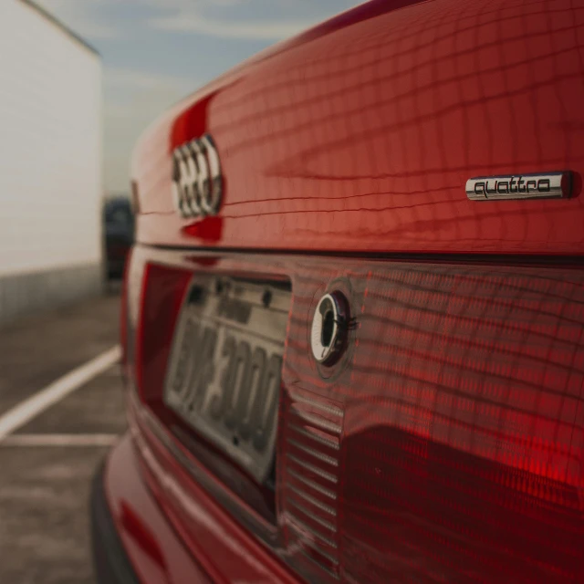 a red car parked in a parking lot, by Adam Marczyński, pexels contest winner, photorealism, audi a4 b6 avant (2002), close-up shot from behind, back light, micro detail 4k