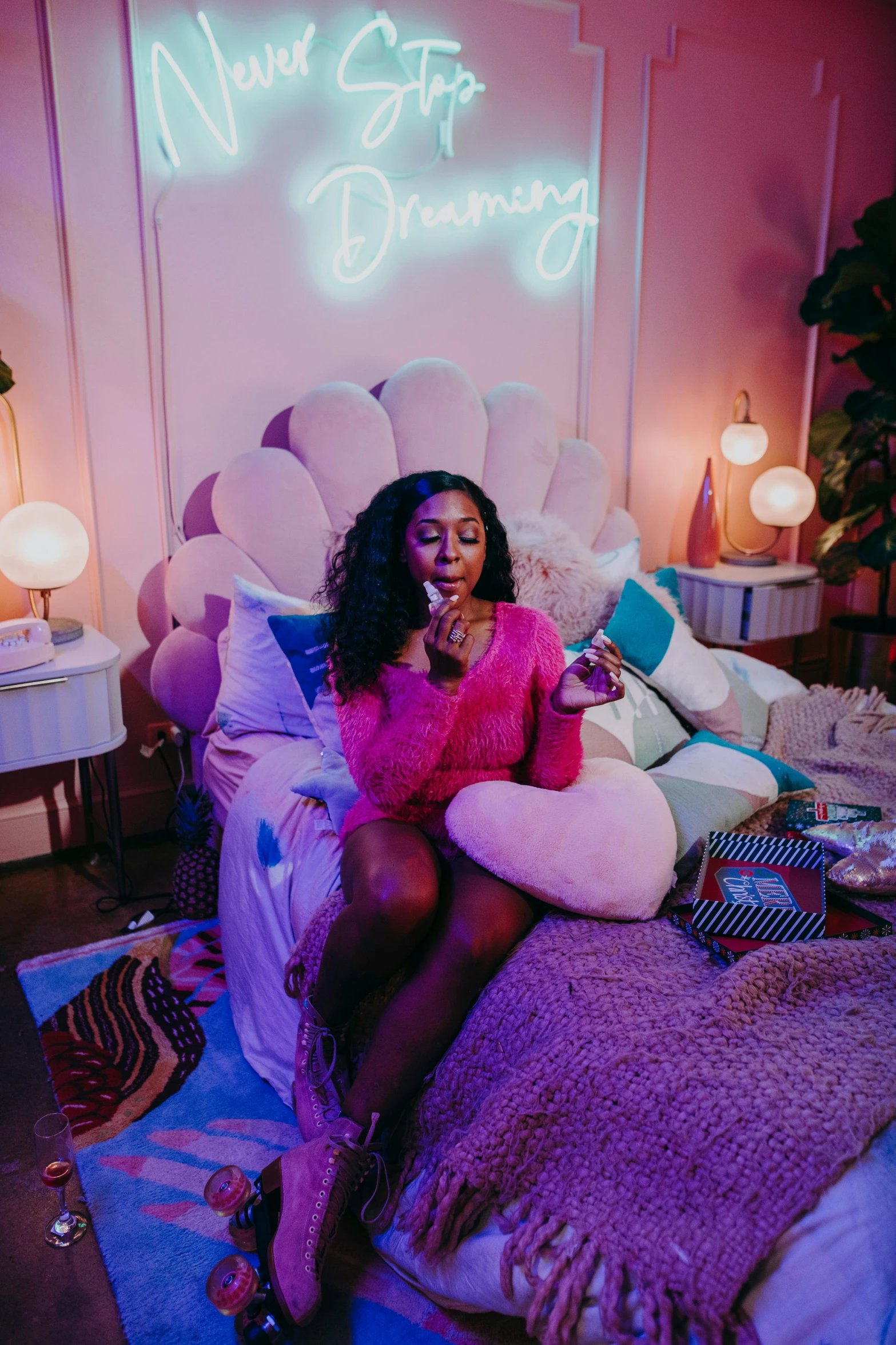 a woman sitting on a bed in front of a neon sign, an album cover, trending on pexels, bubble gum, ( ( dark skin ) ), smoking a magical bong, candy hospital room