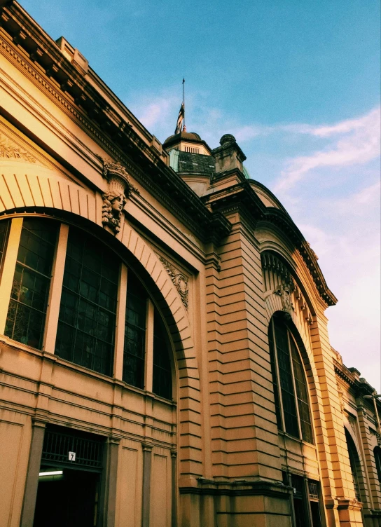 a building with a clock on top of it, trending on unsplash, paris school, manila, low quality photo, bathed in golden light, train station