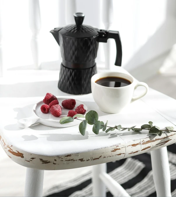 a white plate topped with raspberries next to a cup of coffee, a still life, inspired by Ceferí Olivé, instagram, romanticism, black furniture, detailed product image, portrait image, vintage photo