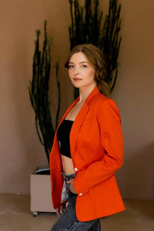 a woman in an orange jacket posing for a picture, wearing a blazer, sydney sweeney, tailored clothing, profile image