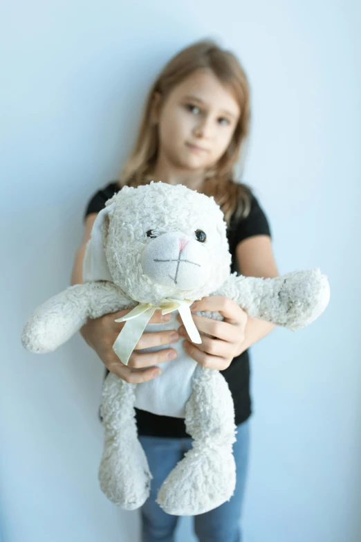 a little girl holding a stuffed animal in her hands, inspired by Maurice Sendak, pexels, silver，ivory, he is sad, product introduction photo, young teen