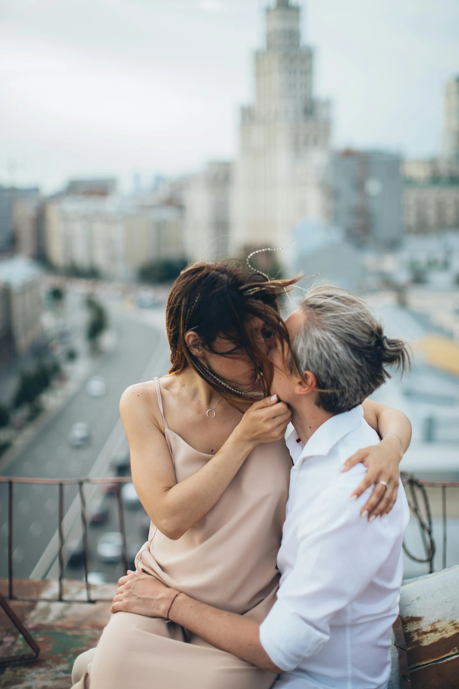 a man and a woman sitting on top of a building, trending on unsplash, romanticism, lesbian kiss, older woman, ukrainian, wide open wife mouth