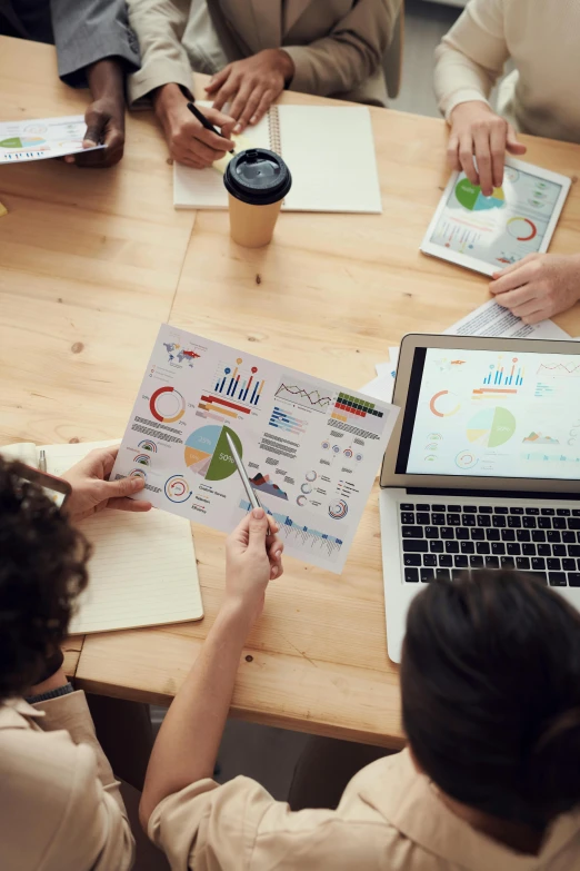 a group of people sitting around a wooden table, a digital rendering, trending on unsplash, analytical art, graphs, square, vp of marketing, sustainable materials