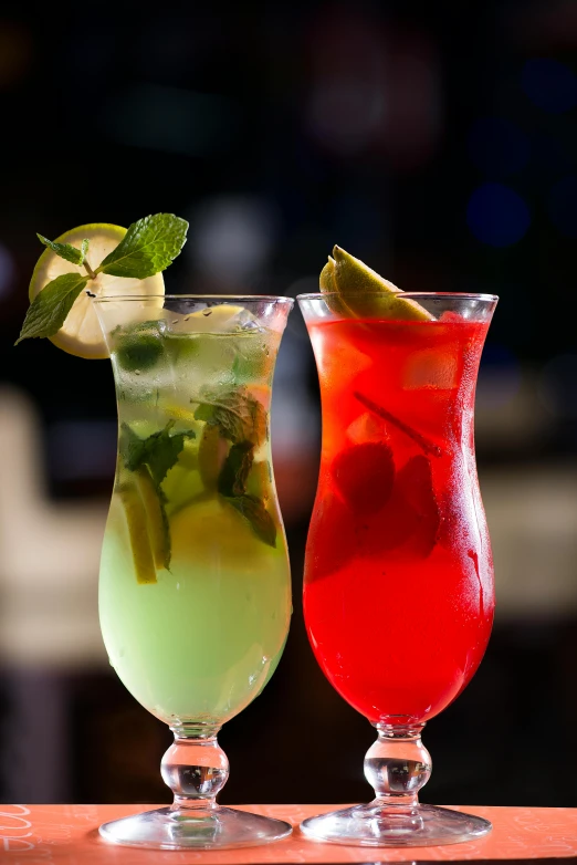 a couple of drinks sitting on top of a wooden table, red and green, lemonade, daily specials, night club