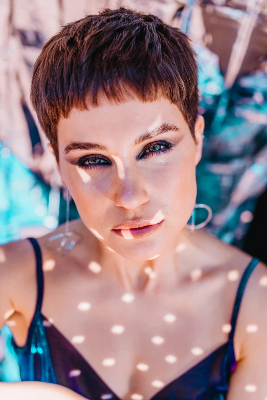 a woman in a blue dress posing for a picture, an album cover, trending on pexels, pixie cut, with bright blue eyes, sanja stikovic, raphael personnaz