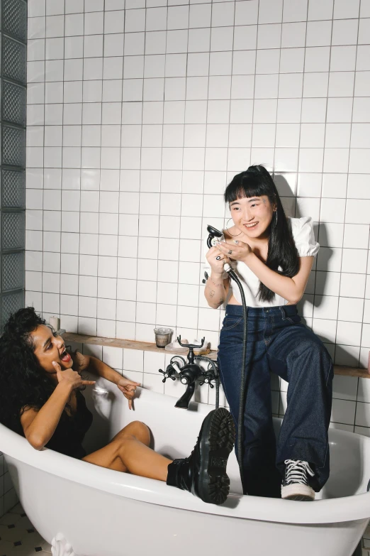 a woman blow drying another woman's hair in a bathtub, an album cover, inspired by Wang Duo, unsplash, gutai group, selena quintanilla perez, sitting on the floor, good friends, asian descent