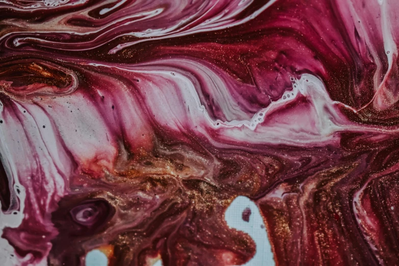 a close up of a painting on a table, by Sophie Pemberton, trending on pexels, abstract art, maroon metallic accents, made of liquid, swirl, unknown artist