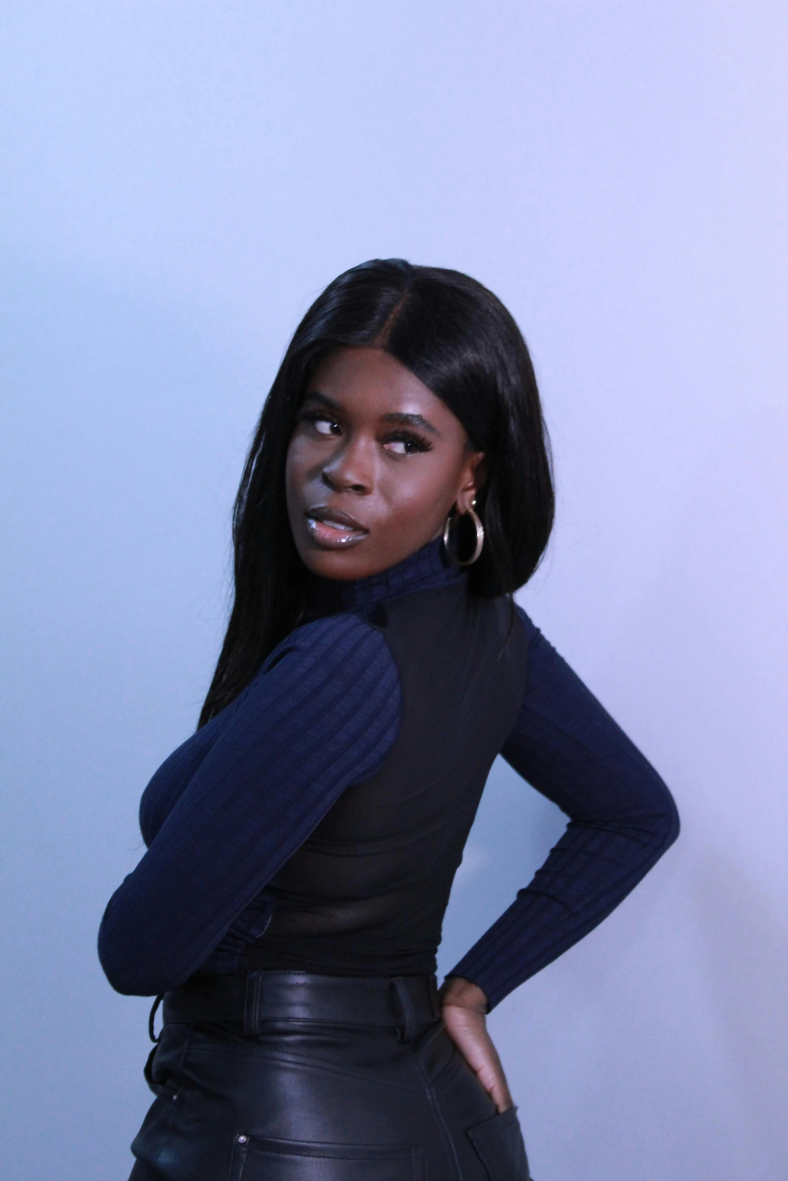 a woman posing with her hands on her hips, an album cover, inspired by Theo Constanté, trending on pexels, hurufiyya, blue turtleneck, in a photo studio, vanessa blue, headshot profile picture