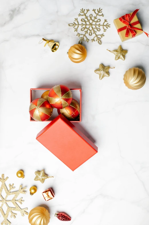 a red gift box sitting on top of a white table, golden orbs, wide overhead shot, orange details, promo image