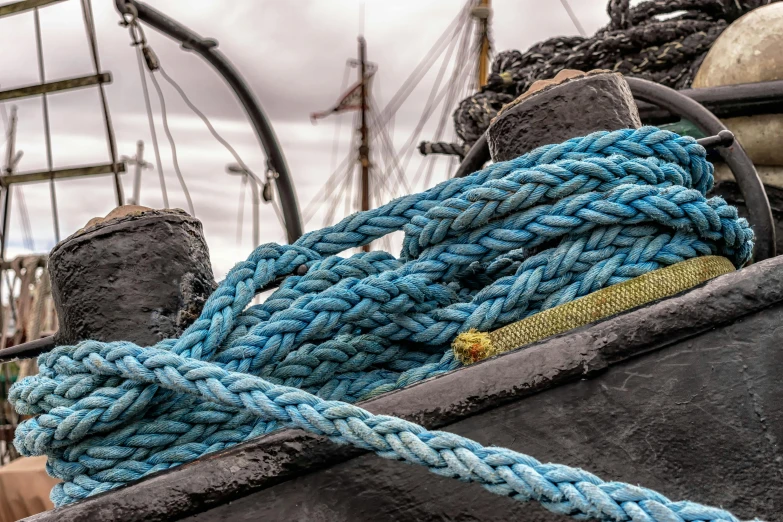 a close up of a rope on a boat, by Adam Marczyński, pexels contest winner, colourised, thumbnail, blue and black, sailing ships