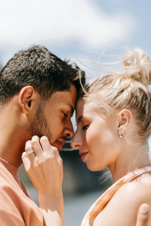 a man and a woman standing next to each other, trending on pexels, touching heads, tan complexion, blonde man, rings