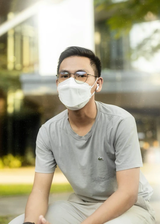a man sitting on a bench wearing a face mask, a picture, bao pham, tech face, very hazy, confident looking