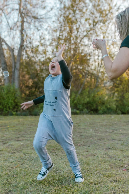 a woman and a child playing with a frisbee, an album cover, pexels contest winner, happening, overalls, bubble, grey, bouncing