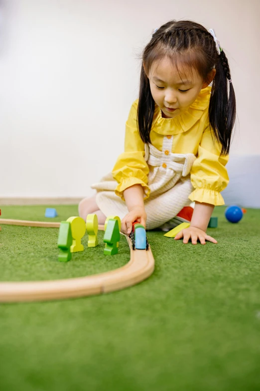 a little girl playing with a train set, fake grass, ai yazawa, sustainable materials, 1 2 9 7