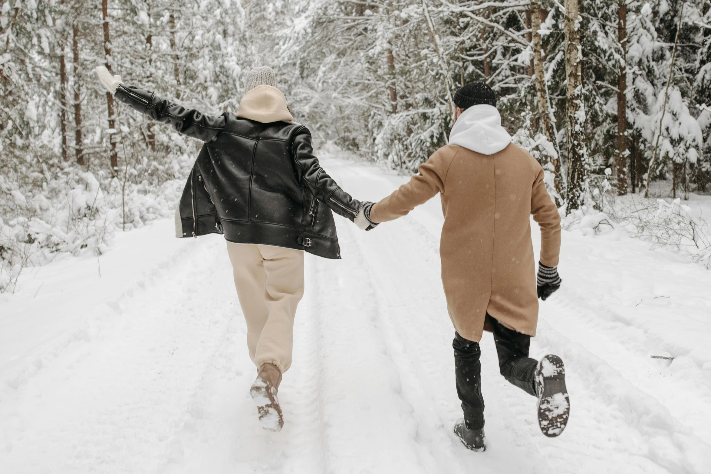 two people walking in the snow holding hands, pexels contest winner, leather clothes, excited, tan, snapchat photo