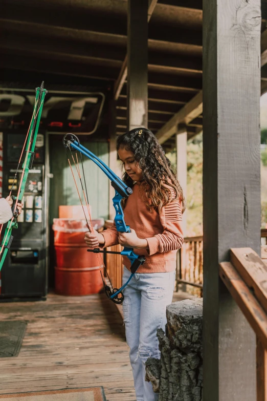 a couple of women standing next to each other on a porch, by Drew Tucker, pexels contest winner, hold mechanical bow and arrow, panoramic view of girl, 2 5 6 x 2 5 6 pixels, blue