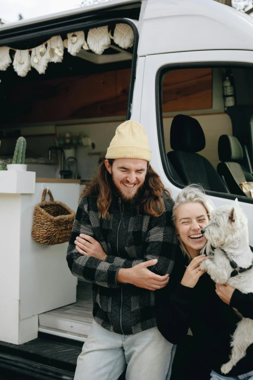 a man and woman standing next to a white van, trending on unsplash, paws on head, smiling, merchants, husband wife and son