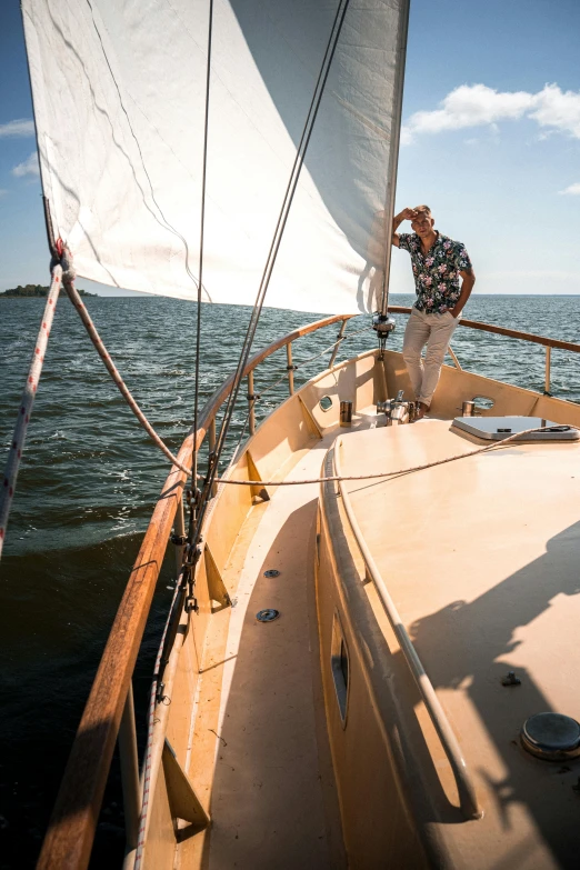 a man standing on the bow of a sailboat, by Jan Tengnagel, happening, low ultrawide shot, wooden boat, summer setting, flattering photo