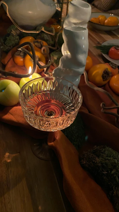 a glass bowl sitting on top of a wooden table, long trunk holding a wand, in style of petra collins, cornucopia, medium close shot