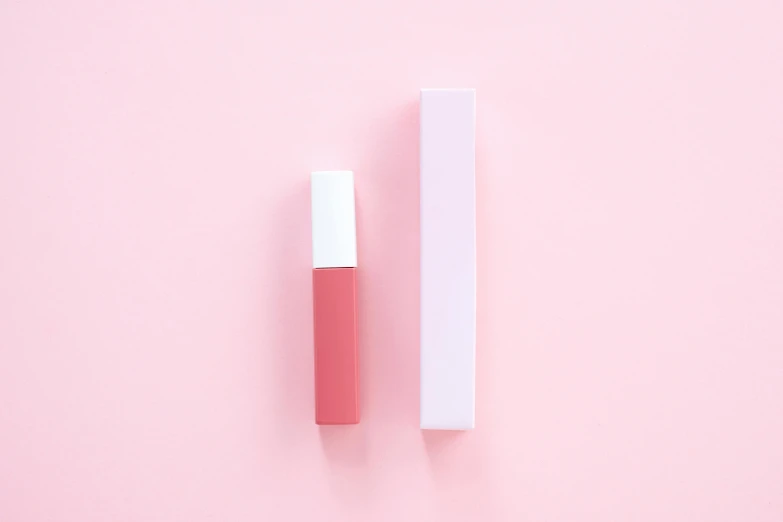 a bottle of pink liquid next to a white box on a pink background, inspired by Yanjun Cheng, unsplash, coral lipstick, gloss finish, muted colors with minimalism, 3 mm