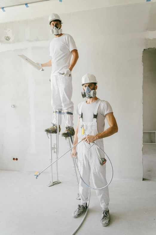 a couple of men standing on top of a ladder, pexels contest winner, arbeitsrat für kunst, wearing a plug suit, walls are made of dry wall, cables hanging from ceiling, white