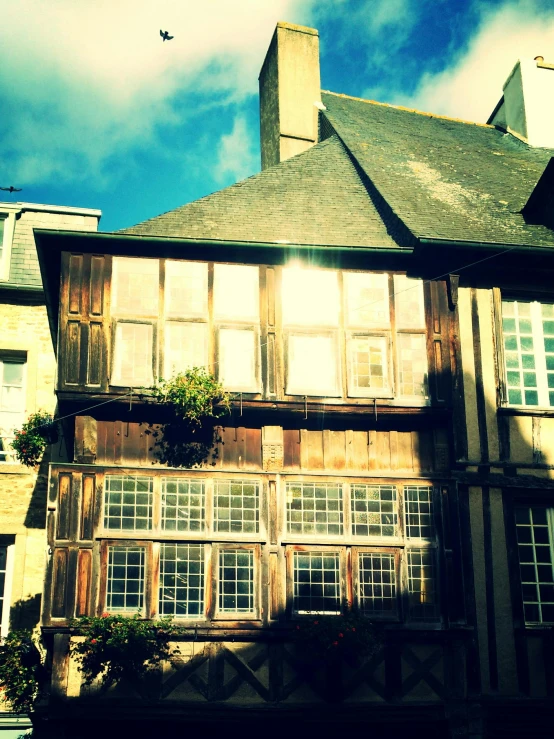 a building with lots of windows and a bird flying in the sky, an album cover, inspired by Villard de Honnecourt, unsplash, arts and crafts movement, rennes - le - chateau, low quality grainy, courtyard, restaurant!