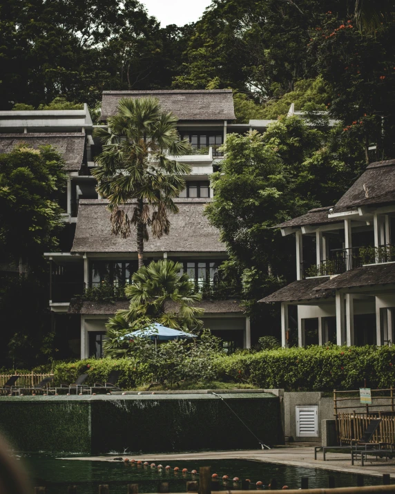 a couple of buildings next to a body of water, tropical trees, exterior shot, terraced, instagram picture