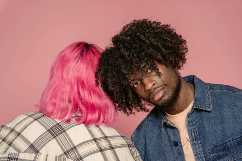 a man standing next to a woman with pink hair, trending on pexels, a black man with long curly hair, lesbians, over it's head, coloured