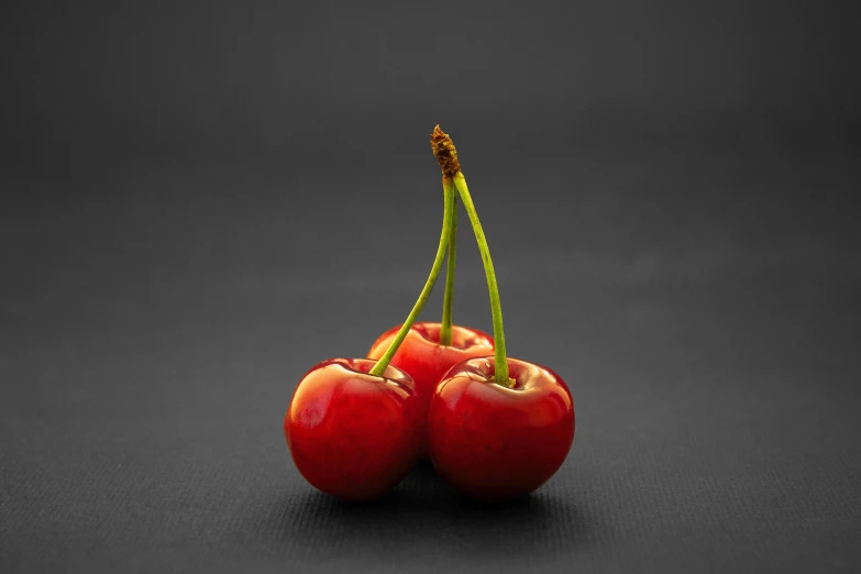 two cherries sitting next to each other on a black surface, unsplash, hyperrealism, 15081959 21121991 01012000 4k, high quality product photo, medium format, cherry blossums