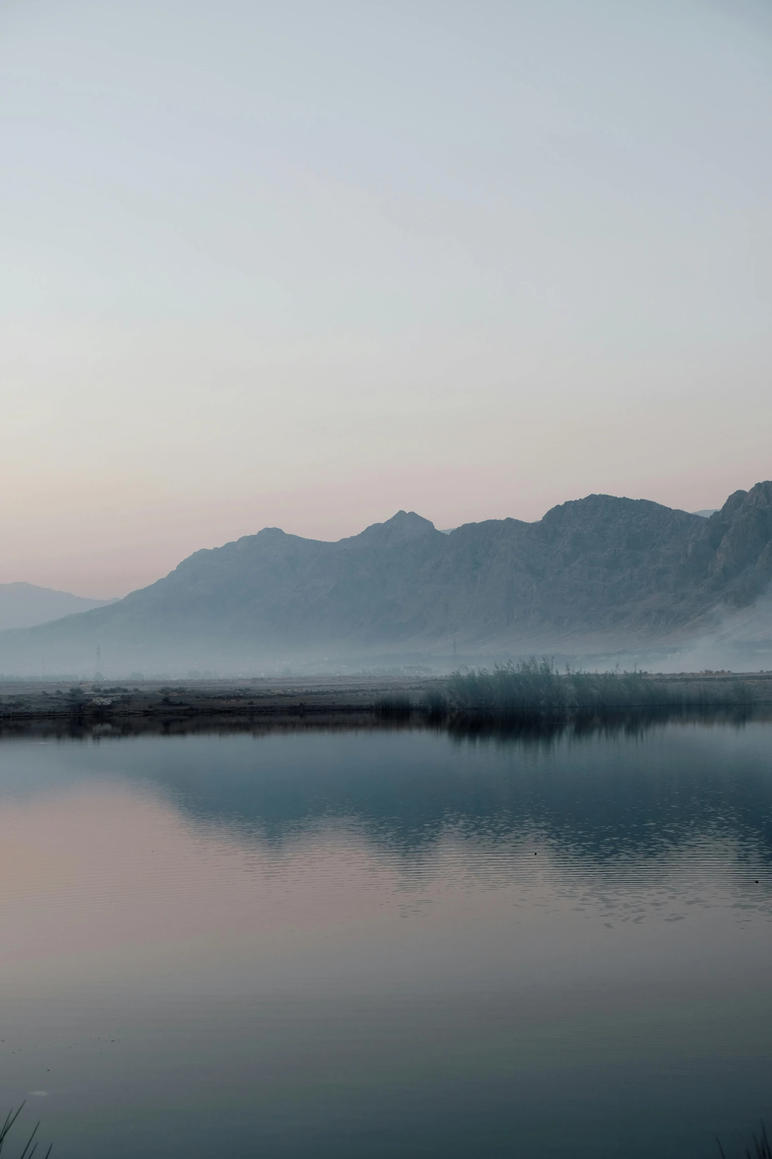 a body of water with mountains in the background, a picture, inspired by Zhang Kechun, minimalism, early morning sunrise, kurdistan, :: morning, ultrawide landscape