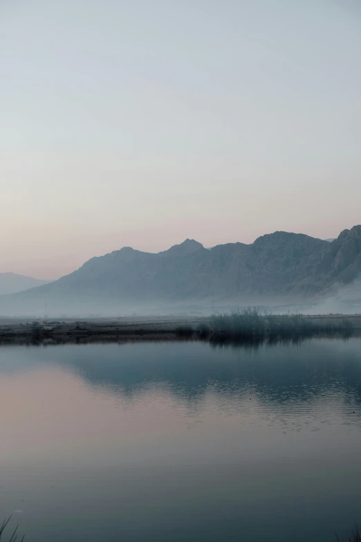 a body of water with mountains in the background, a picture, inspired by Zhang Kechun, minimalism, early morning sunrise, kurdistan, :: morning, ultrawide landscape