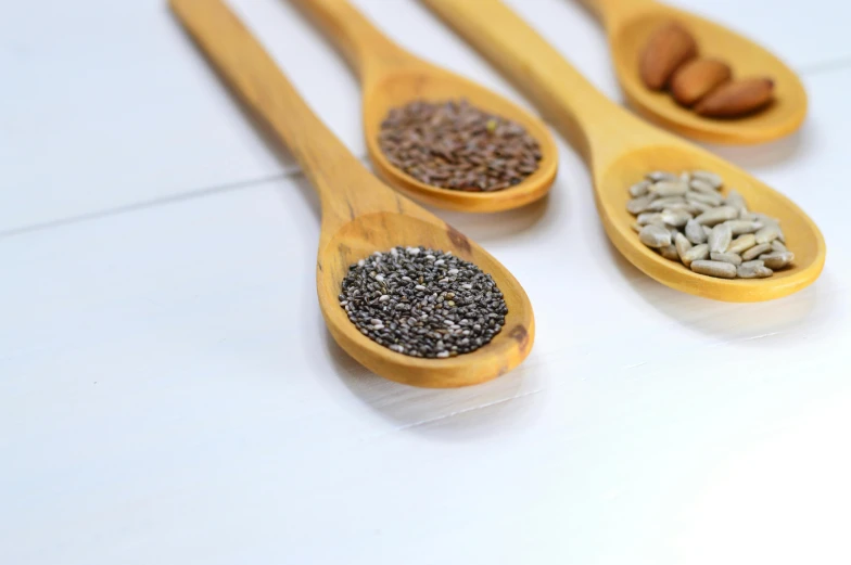four wooden spoons filled with seeds and nuts, pexels, grey colours, terrazzo, with a white background, magnesium