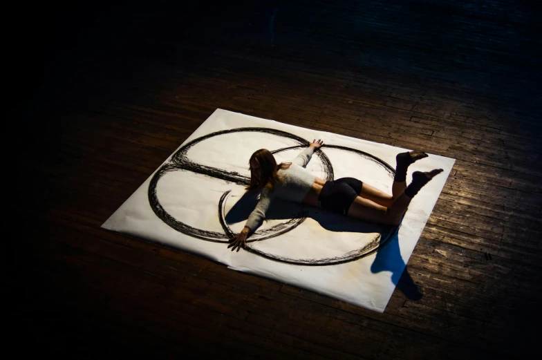 a woman laying on top of a piece of paper, by Nina Hamnett, unsplash, process art, summoning circle, full - body art, choreographed, ink on canvas