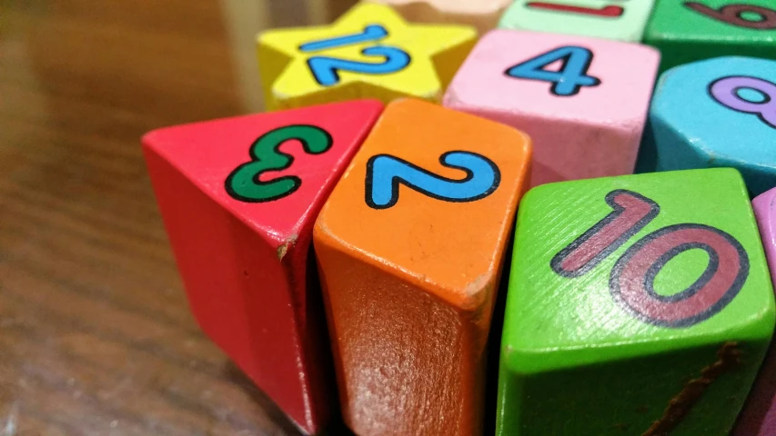 a close up of wooden blocks with numbers on them, pexels, brilliantly coloured, handheld, square, richard pearce