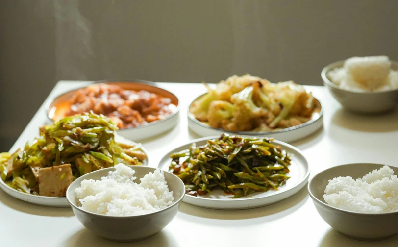 a table topped with plates of food and bowls of rice, inspired by Nam Gye-u, unsplash, mingei, extra pickles and onions, with a white background, background image, ivy's