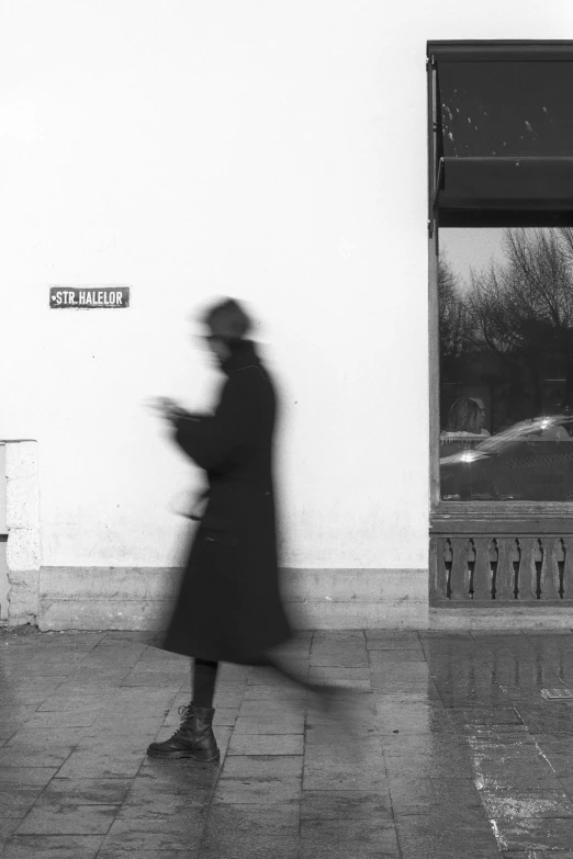 a black and white photo of a person on a skateboard, a black and white photo, inspired by Louis Stettner, postminimalism, ( ( wearing a long coat ) ), a woman walking, ( conceptual art ), a mysterious